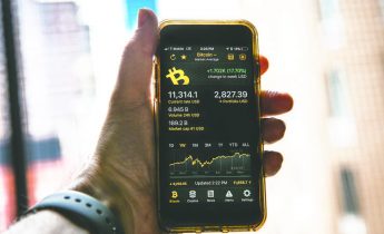 Смартфон показывает текущий курс биткойна