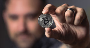 биткоин монета в руке человека